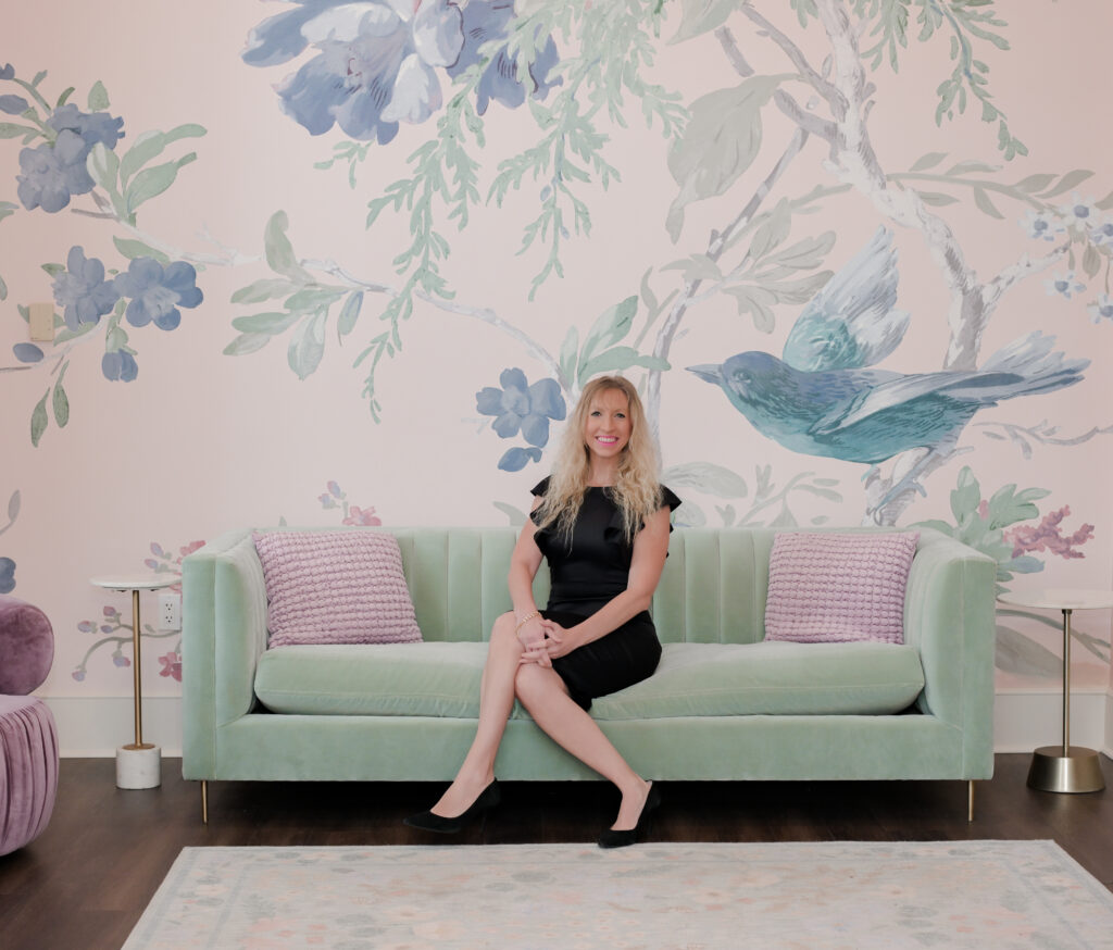 Elle Rudisill sitting on a sage couch